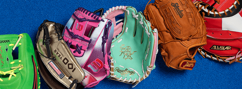Six baseball gloves in various leather finishes—including green, tan, pink, brown, and red—arranged in a row against a blue background.