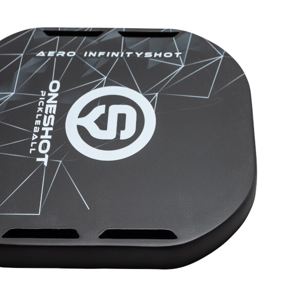 Top-down view of a black pickleball paddle with white ONESHOT PICKLEBALL text, a circular logo, and AERO INFINITYSHOT text.