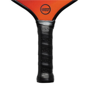 Close-up of a black pickleball paddle grip with a USAPA Approved logo on the orange paddle head.