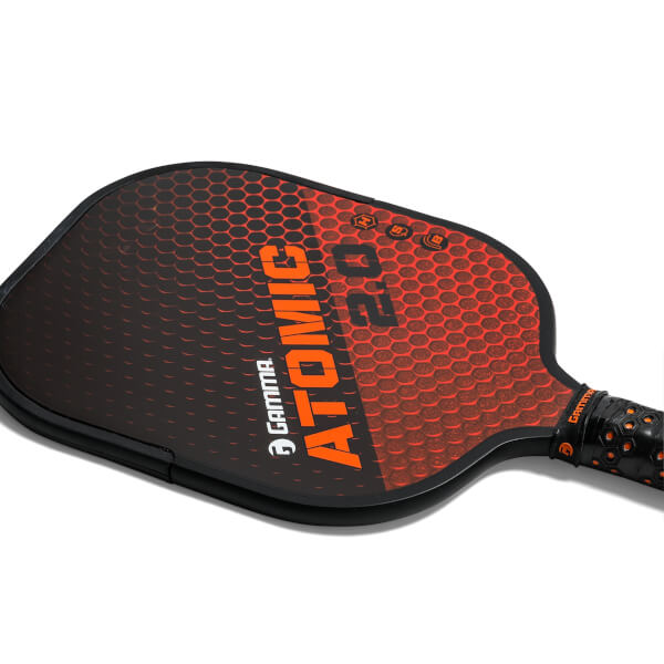 Top-down view of a black and orange GAMMA Atomic 2.0 pickleball paddle with honeycomb pattern and textured grip.
