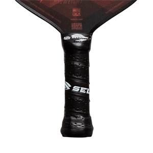 Close-up of a black pickleball paddle grip with a textured surface and white Selkirk branding.
