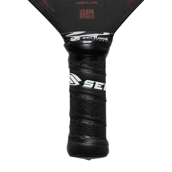 Close-up of a black pickleball paddle grip with SE logo and Selkirk Sport branding.