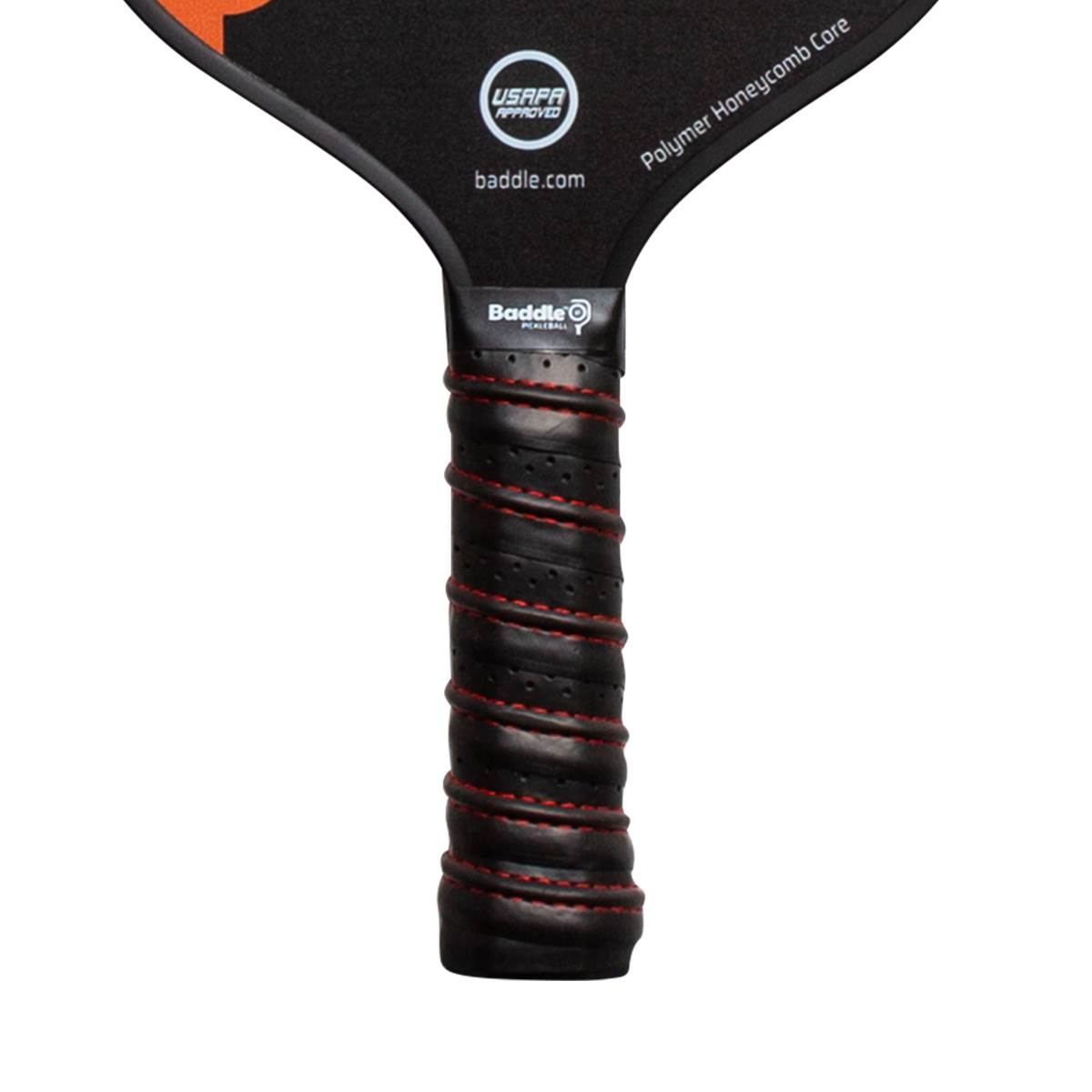 Close-up of a black pickleball paddle grip with red stitching and a Baddle logo.