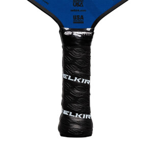 Close-up of a black pickleball paddle grip with embossed SELKIRK text and a textured pattern.