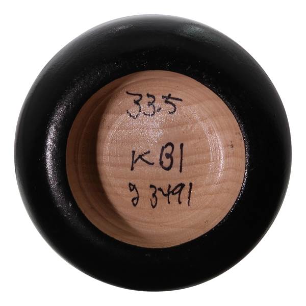End view of a black baseball bat with 33.5, KB1, and 9 3491 written on the wood.