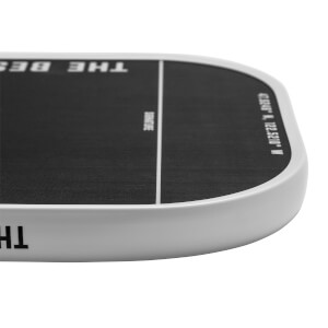 Corner view of a black pickleball paddle with white text THE BEST and coordinates.