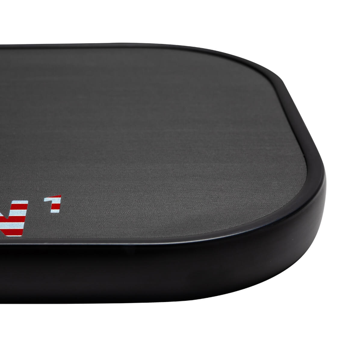 Corner view of a black pickleball paddle with a textured surface and red and white stripes.