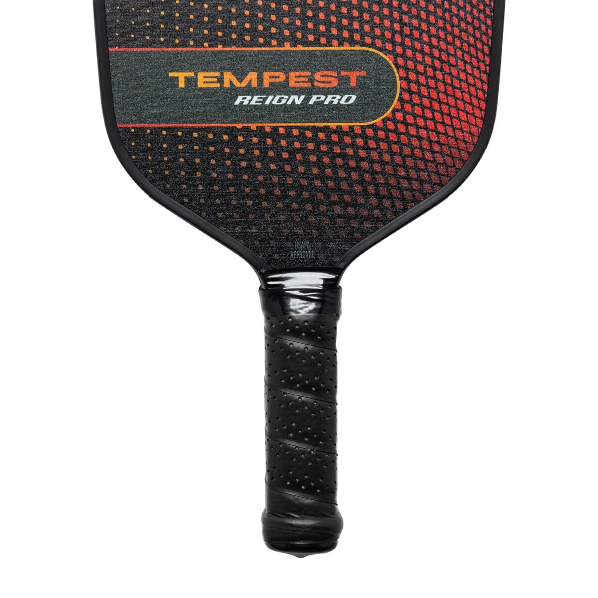 Top-down view of a black pickleball paddle with TEMPEST REIGN PRO text and a gradient orange and black pattern.