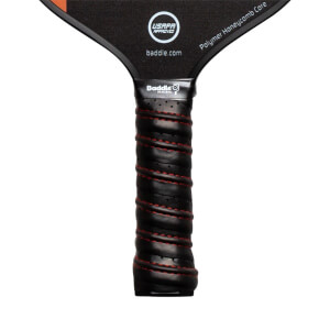 Close-up of a black pickleball paddle grip with red stitching and Baddle branding.