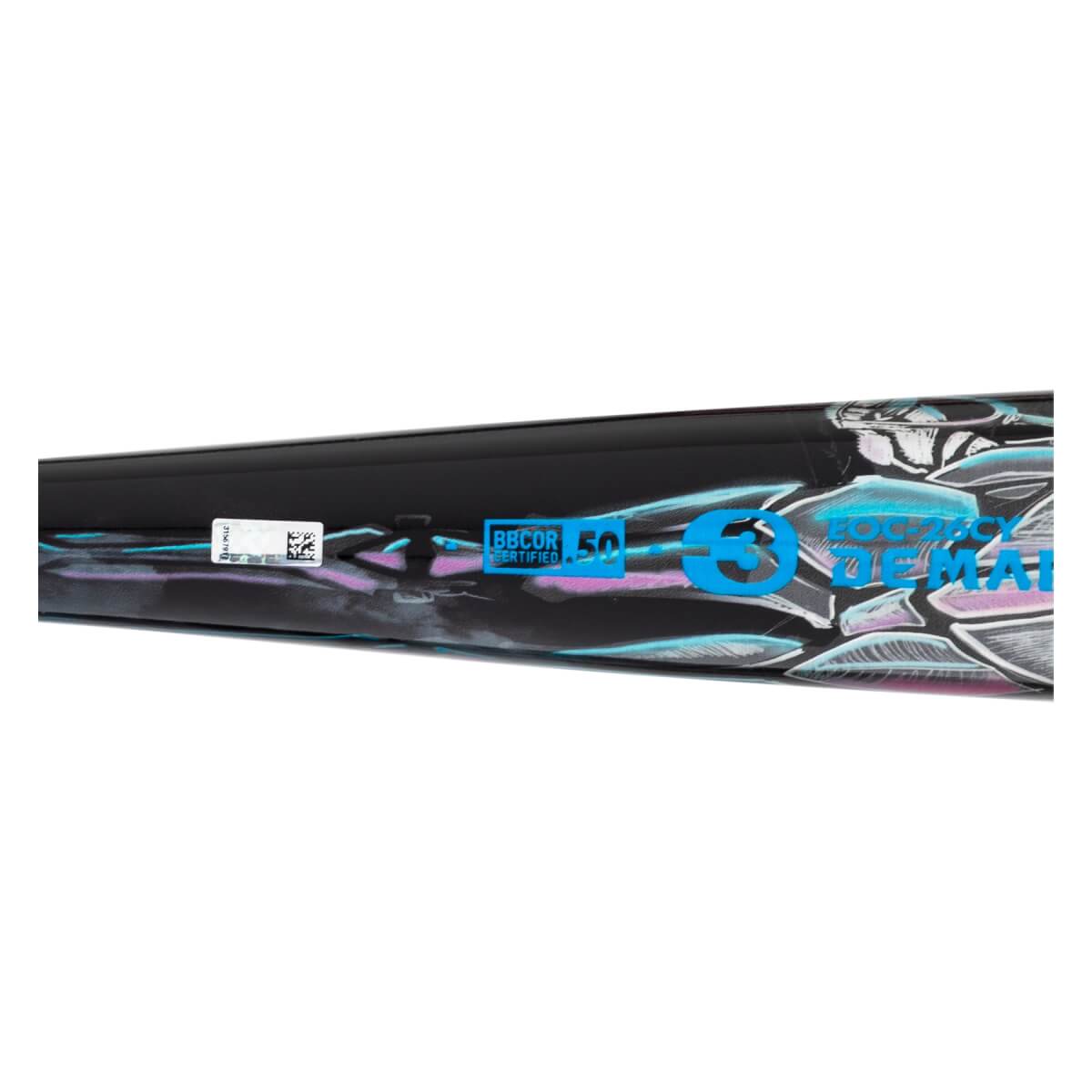 Close-up of a black baseball bat with a blue BBCOR stamp, DeMarini text, and abstract scale graphics in blue and pink.