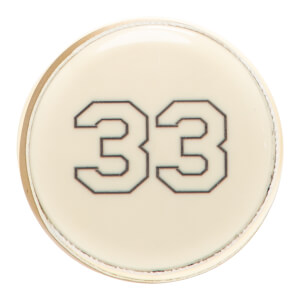 Close-up of a cream circular softball bat end cap with a thin gold rim and the number 33 in black outline.