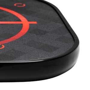 Corner view of a black pickleball paddle with a red target design and textured surface.
