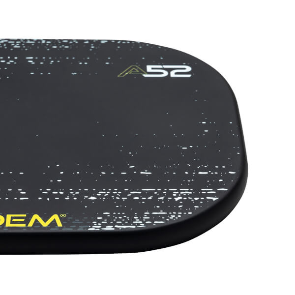 Corner view of a black pickleball paddle with white speckle pattern and A52 logo.