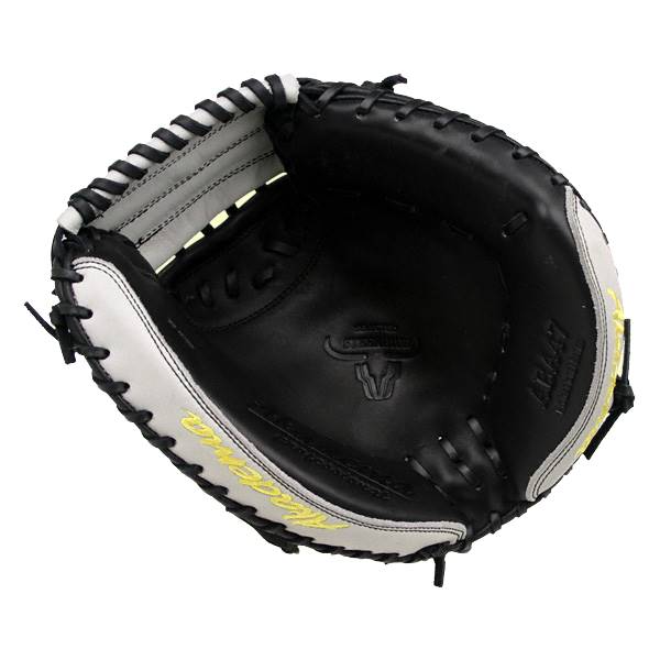 Top-down view of a black and white catchers mitt with yellow Akadema text and a bull logo.