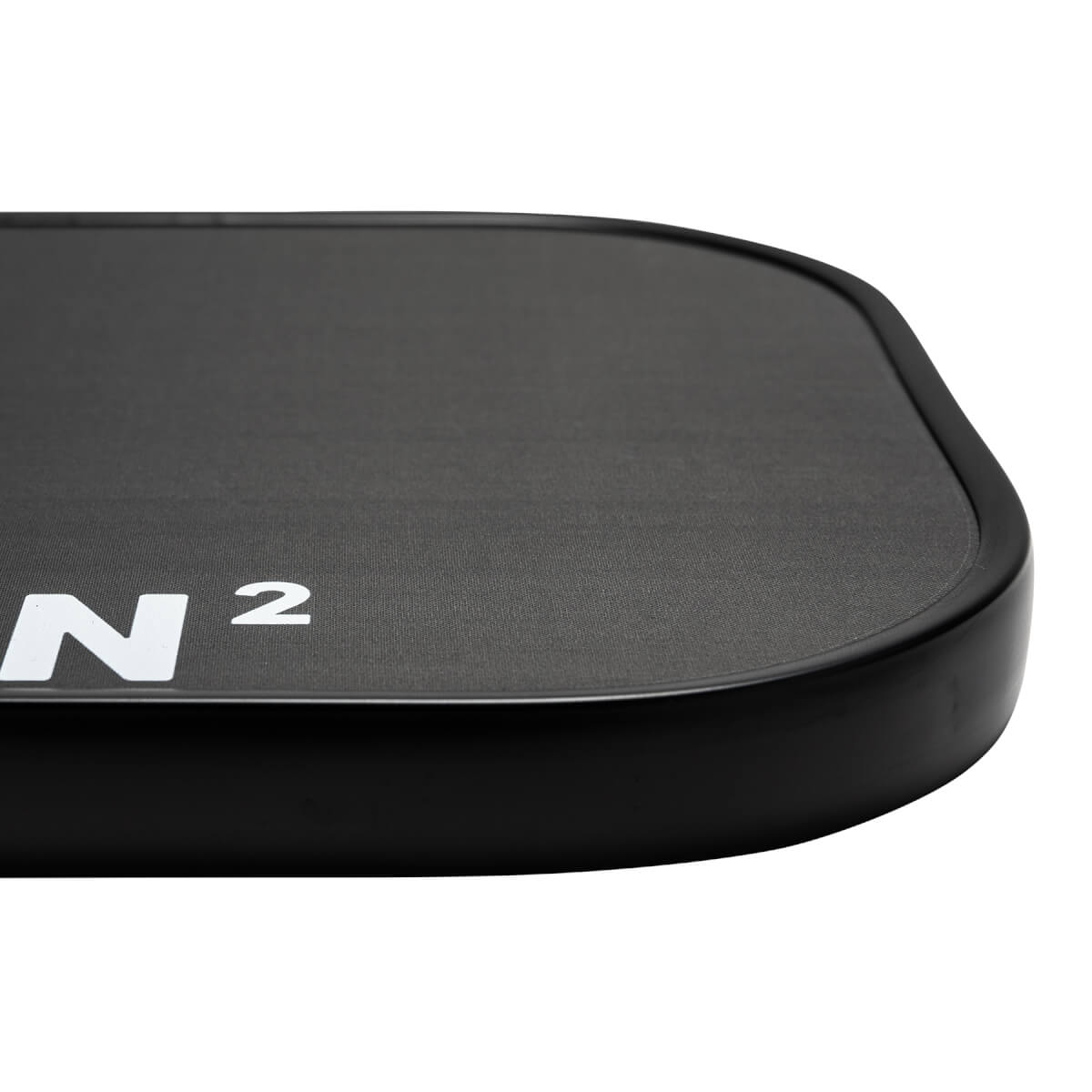Corner view of a black pickleball paddle with white N and 2 branding and a textured surface.