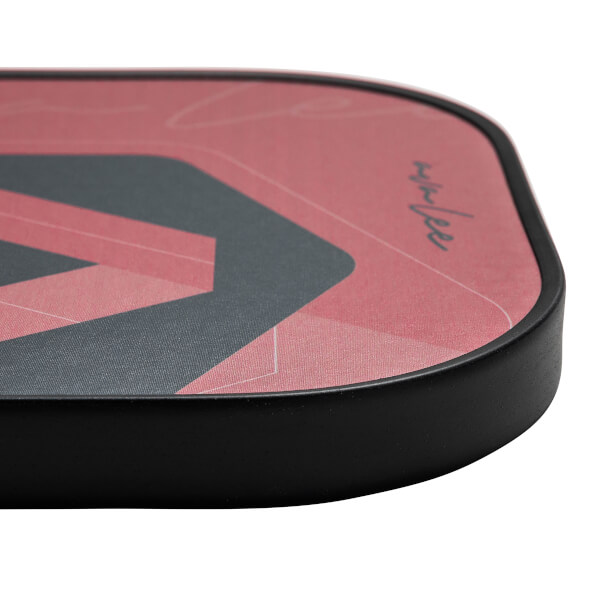 Corner view of a red pickleball paddle with a black geometric design and AvaLee signature.