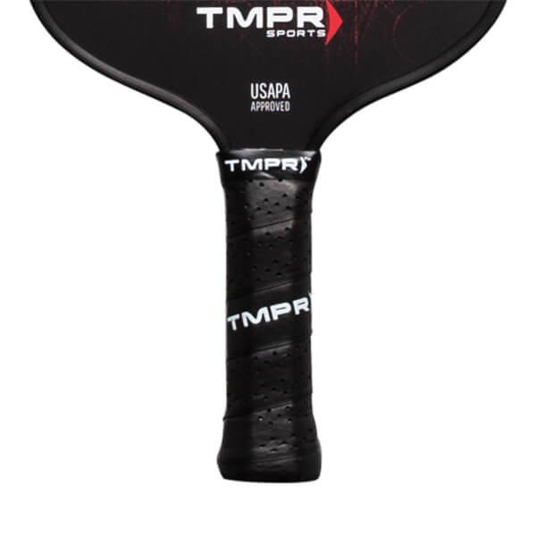 Close-up of a black pickleball paddle grip with perforations and TMPR branding.