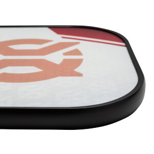 Corner view of a white pickleball paddle with a large orange graphic and red accents.
