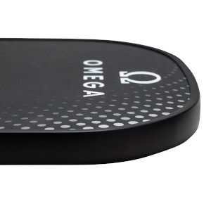 Corner view of a black pickleball paddle with white OMEGA text and a dotted pattern.