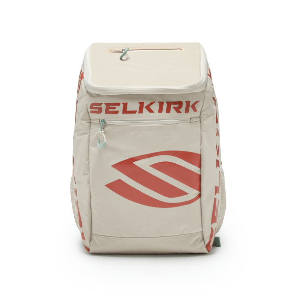 Front view of a beige backpack with a red "SELKIRK" logo, a large red stylized swoosh, and a zippered pocket.