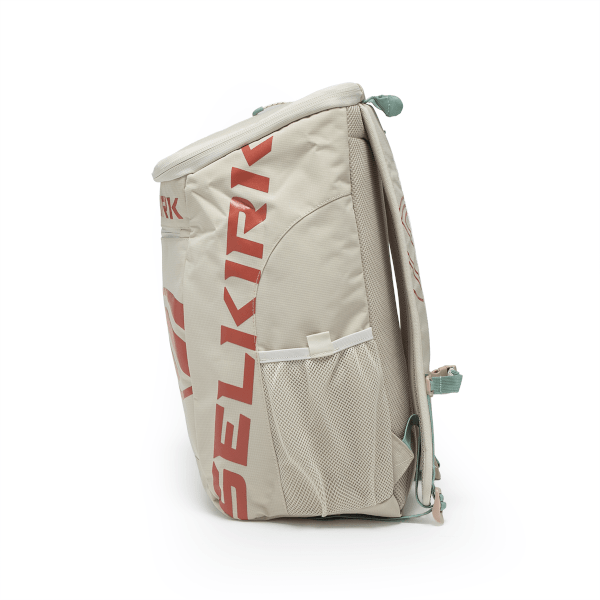 Side view of a light-colored backpack with red "SELKIRK" lettering, mesh side pockets, and teal accents.
