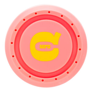 Top-down view of the pink bat knob featuring a yellow stylized "C" logo with "MFG" in the center and a ring of small circular indentations.