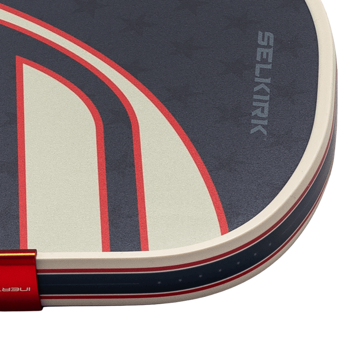 Close-up corner view of a navy blue textured paddle featuring red and white graphic accents and the brand name "SELKIRK" printed vertically.