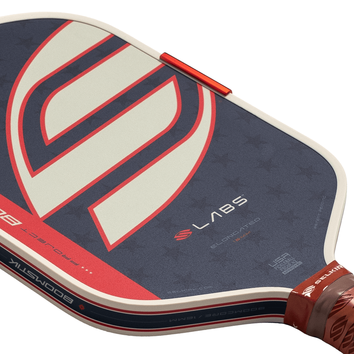 Close-up diagonal view of a blue pickleball paddle featuring a large red and white stylized S logo and the words LABS, PROJECT 002, and BOOMSTIK.