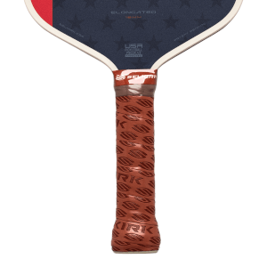 Close-up of a Selkirk pickleball paddle's brown textured grip and navy face featuring stars, "ELONGATED 16MM," and "USA PICKLEBALL APPROVED" text.