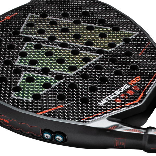 Close-up of a black padel racket face featuring the "METALBONE HRD" text, green diamond patterns, and circular holes.