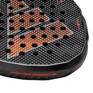 Close-up view of a black padel racket face showing orange geometric accents, black honeycomb texture, and red "POWER GROOVE" lettering.