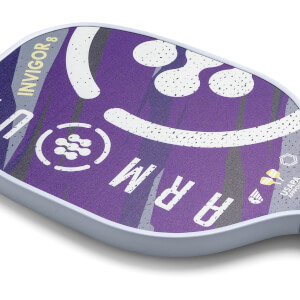 Corner view of a purple pickleball paddle with ARMOUR INVIGOR8 text and a smiley face graphic.