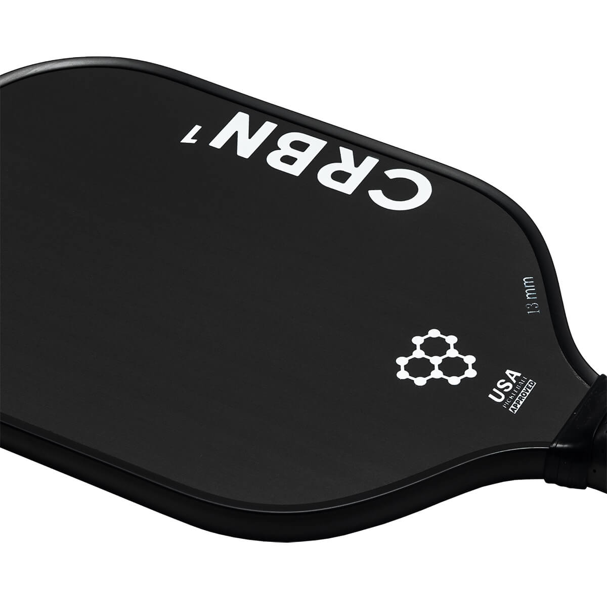 Corner view of a black pickleball paddle with white CRBN¹ branding, a molecular graphic, and USA Pickleball Approved text.