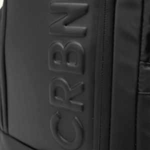 Close-up of the CRBN logo embossed on the side of the black pickleball backpack.