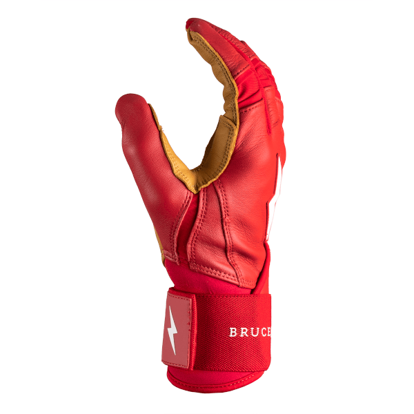 Side view of a red batting glove with tan leather palm, white lightning bolt logo, and "BRUCE" text on the wrist strap.