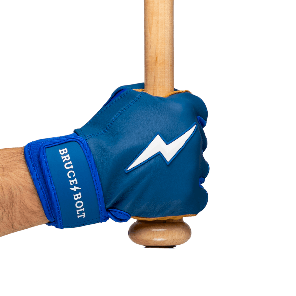 Side view of a blue batting glove with a white lightning bolt and "BRUCE BOLT" text, holding a wooden bat.