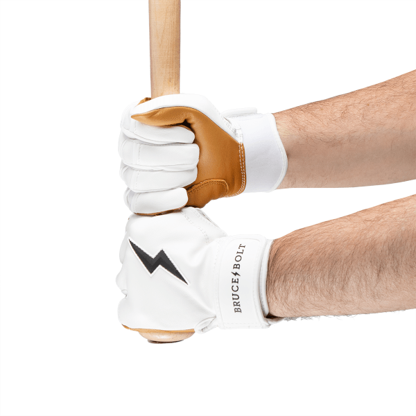 Side view of hands wearing white batting gloves with brown accents and the BRUCE BOLT logo.