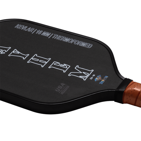 Diagonal view of the back of a black pickleball paddle showing "KEVLAR | 16 MM | THERMOFORMED" and a "NOMAD" logo.