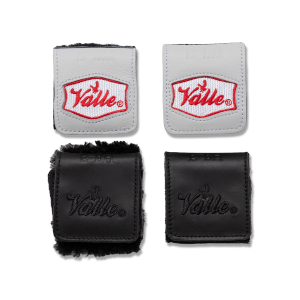 Top-down view of two gray leather patches with red "Valle" branding and two black leather patches with embossed "Valle" branding.