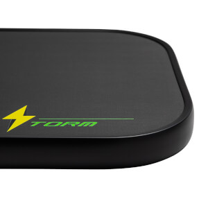 Corner view of a black pickleball paddle with a green lightning bolt and STORM logo.