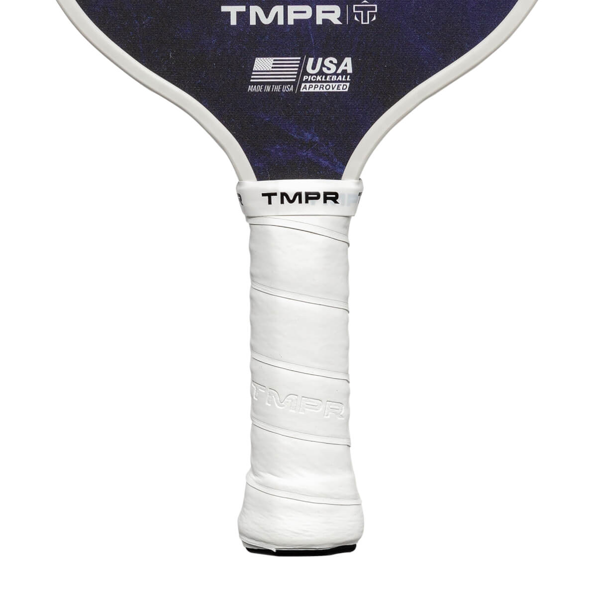 Close-up of a white grip on a pickleball paddle with TMPR branding and USA Pickleball Approved logo.