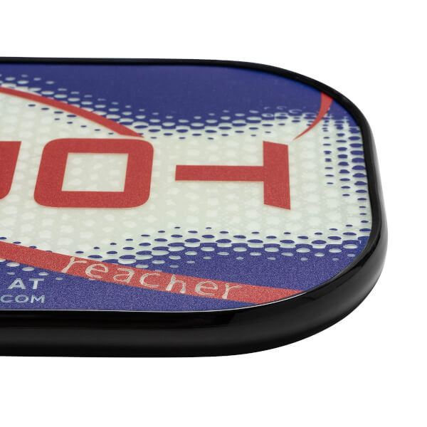 Corner view of a white pickleball paddle with red and blue graphics, showing reacher text.