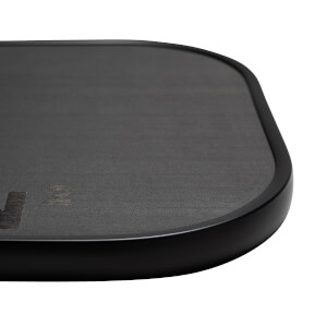 Close-up of a black pickleball paddle with a textured surface and visible CRBN 2 branding.