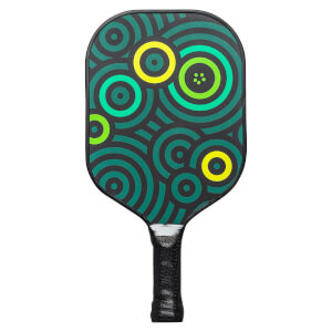 Front view of a black pickleball paddle with a teal and yellow concentric circle pattern and a black grip.