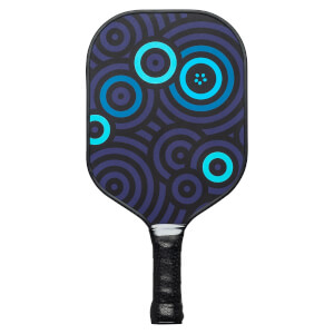 Front view of a dark purple pickleball paddle with a blue concentric circle pattern and black grip.