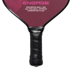 Close-up of a black pickleball paddle grip with perforated texture and Engage branding on the head.