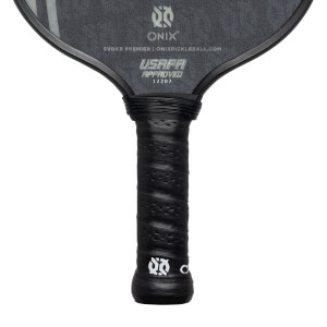 Close-up of a black pickleball paddle grip with perforated texture and USAPA approved stamp.