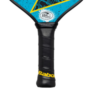 Close-up of a black pickleball paddle grip with yellow Babolat branding and a USA Pickleball Approved logo.