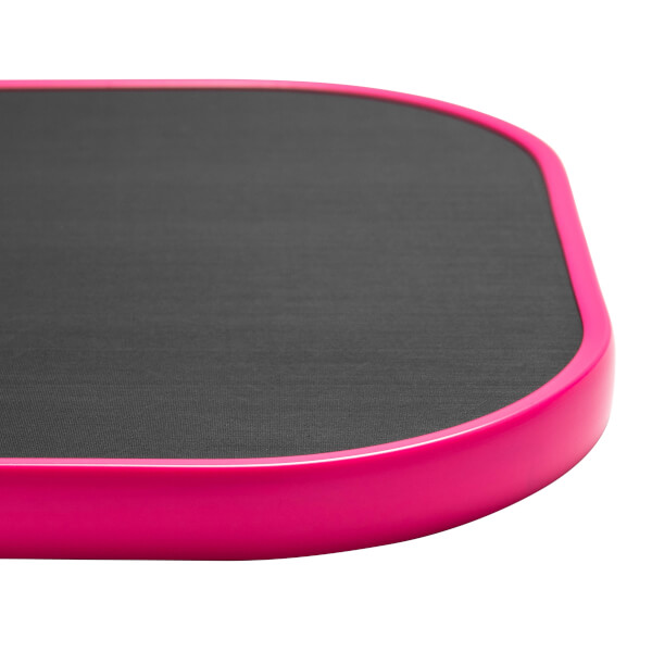 Corner view of a pink pickleball paddle with a textured black surface.