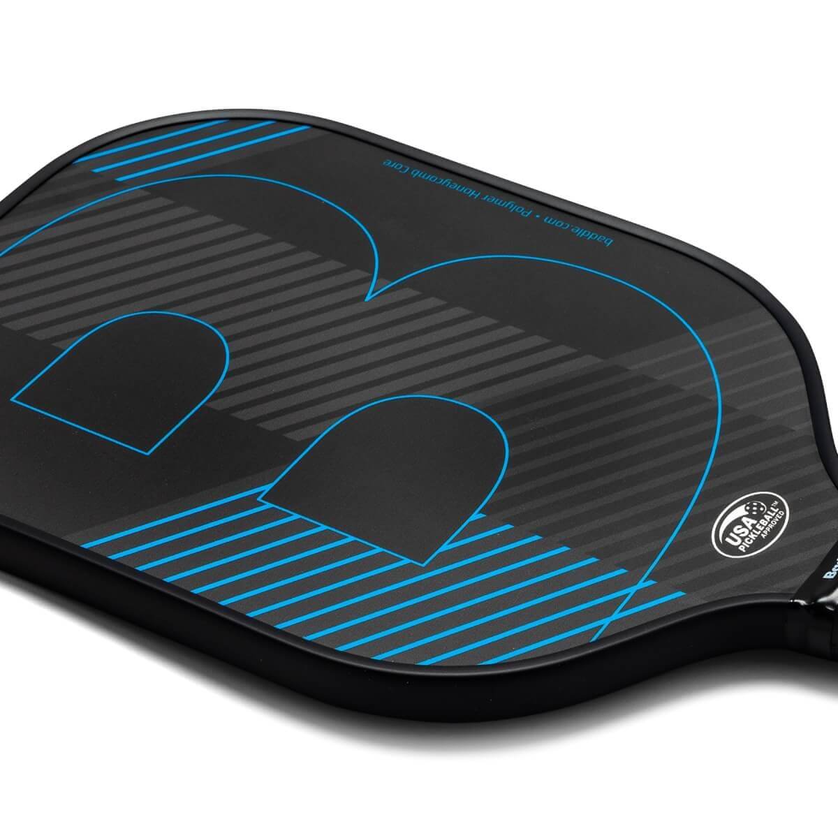 Corner view of a black pickleball paddle with blue lines, a large blue B logo, and USA Pickleball Approved stamp.